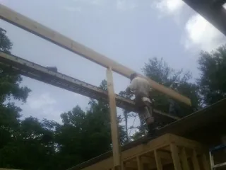 Carpenter setting a ridge beam over a new addition frame — Ice Dam Removal by Roofing Brothers in Mount Gilead