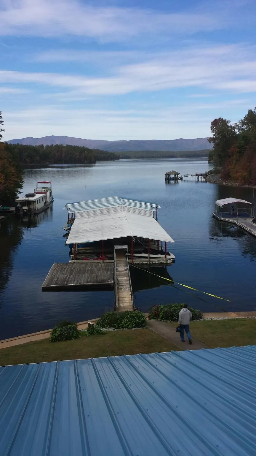 View across a lake from a newly installed blue metal roof in Mount Gilead